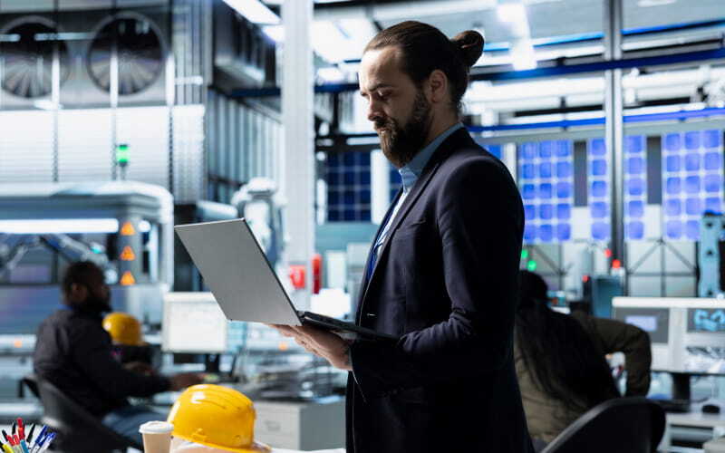 Profesional egresado del programa ingeniería industrial de CUC se desempeñar como líder de proyectos y revisa gestión en su computador.
