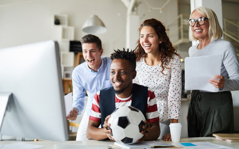 Equipo de marketing se ven felices al validar los resultados de una campaña con una marca de fútbol.