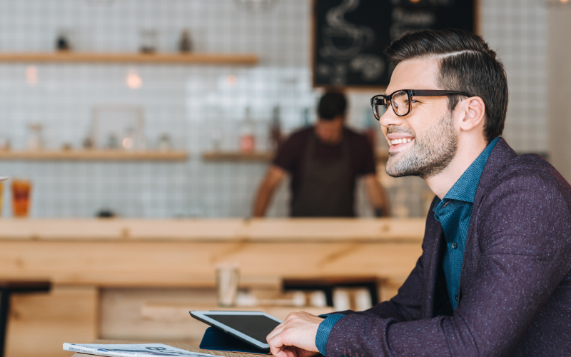 Joven en coworking sonríe después de salir de una sesión para potenciar habilidades de comunicación y liderazgo.
