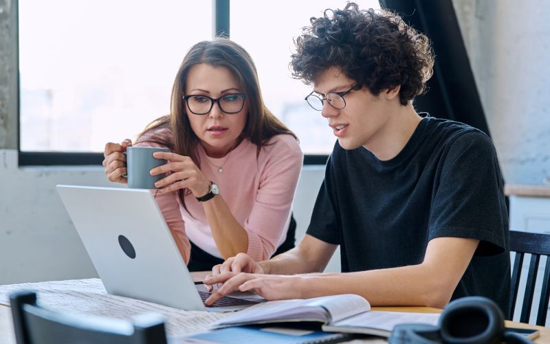 ​Joven estudiante explorando programas académicos con su mamá en el sitio web de la Universidad de la Costa​