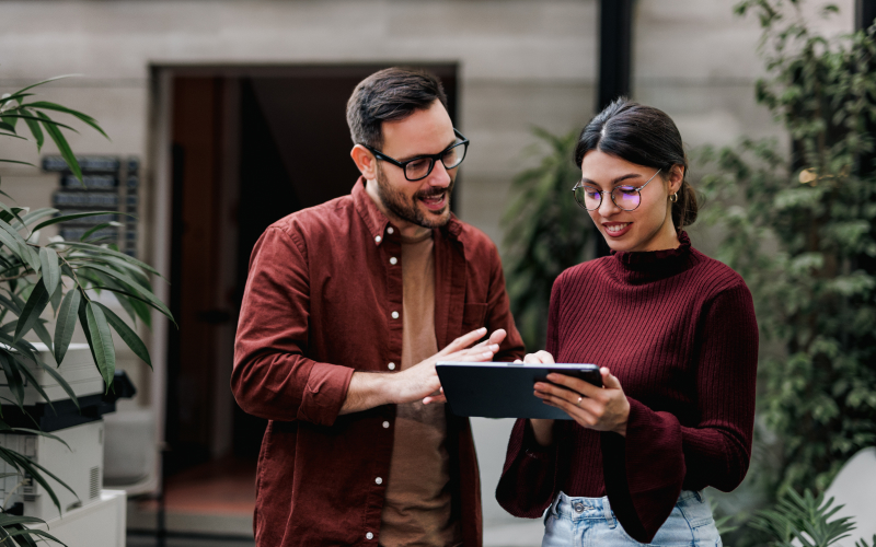 Dos especialistas en sostenibilidad ambiental consultan en tablet posible rango de salarios según nivel de experiencia y cargo.