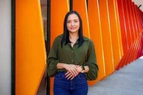 A person standing in front of an orange wall__Description automatically generated